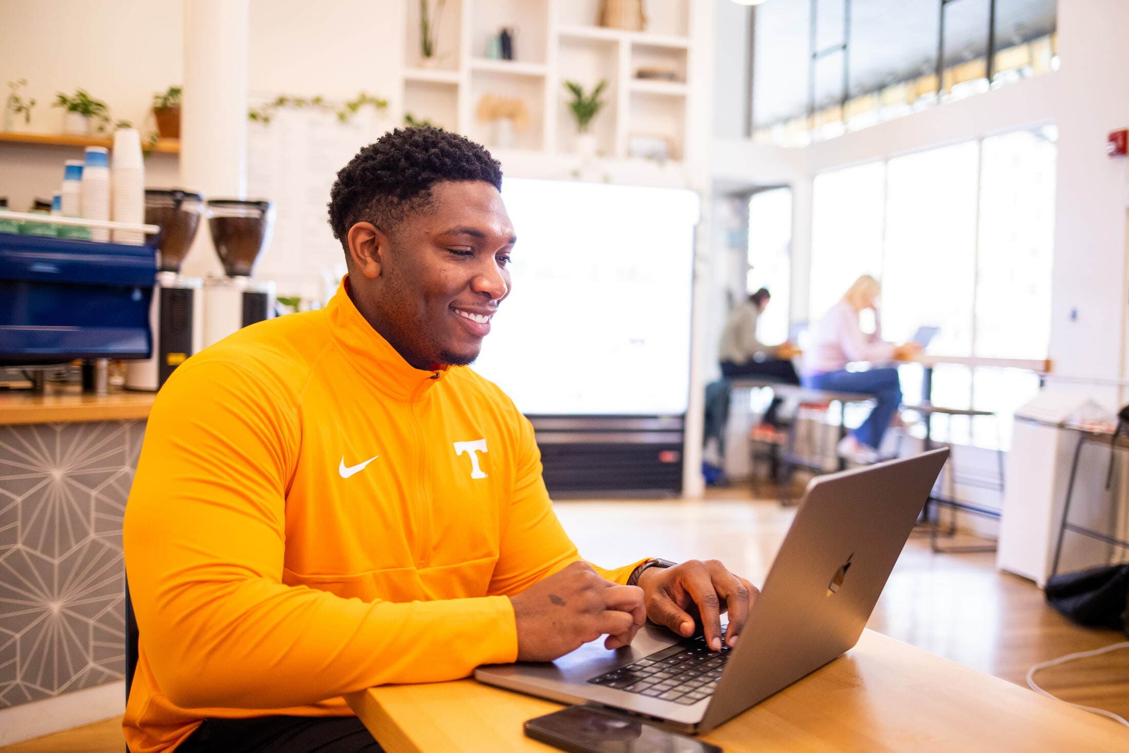 Student in a Tennessee shirt working on a laptop.